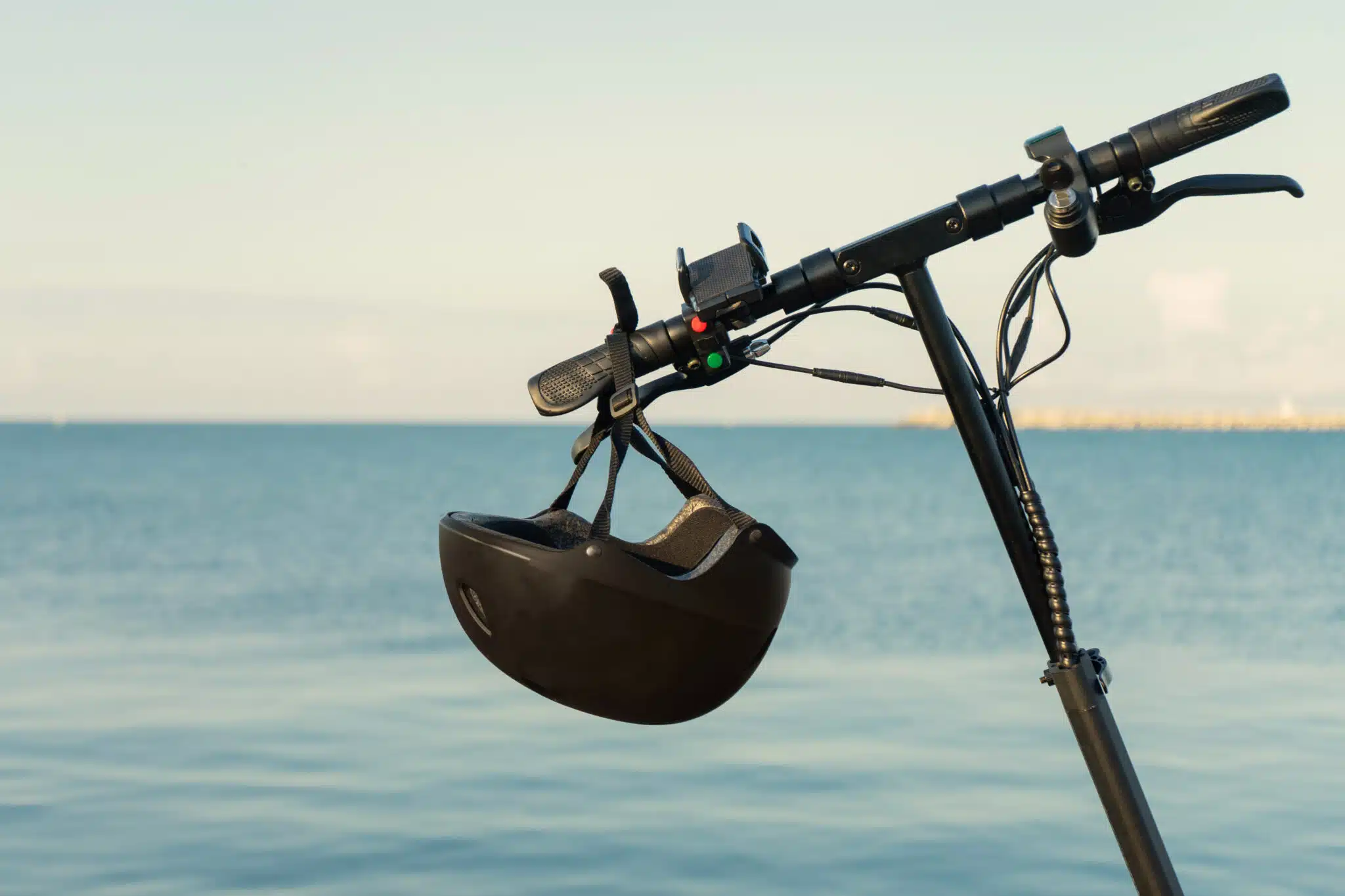 Two people sitting on electric scooter wearing helmets high fiving