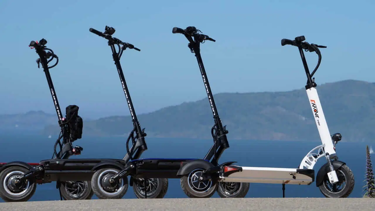 4 electric scooters standing next to eachother