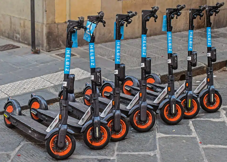 7 electric scooters parked directly next to eachother