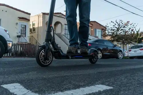 man riding the hiboy max v2 electric scooter on a street