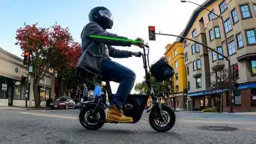 Rider on a seated electric scooter demonstrates good (neutral) wrist position on an electric scooter throttle 