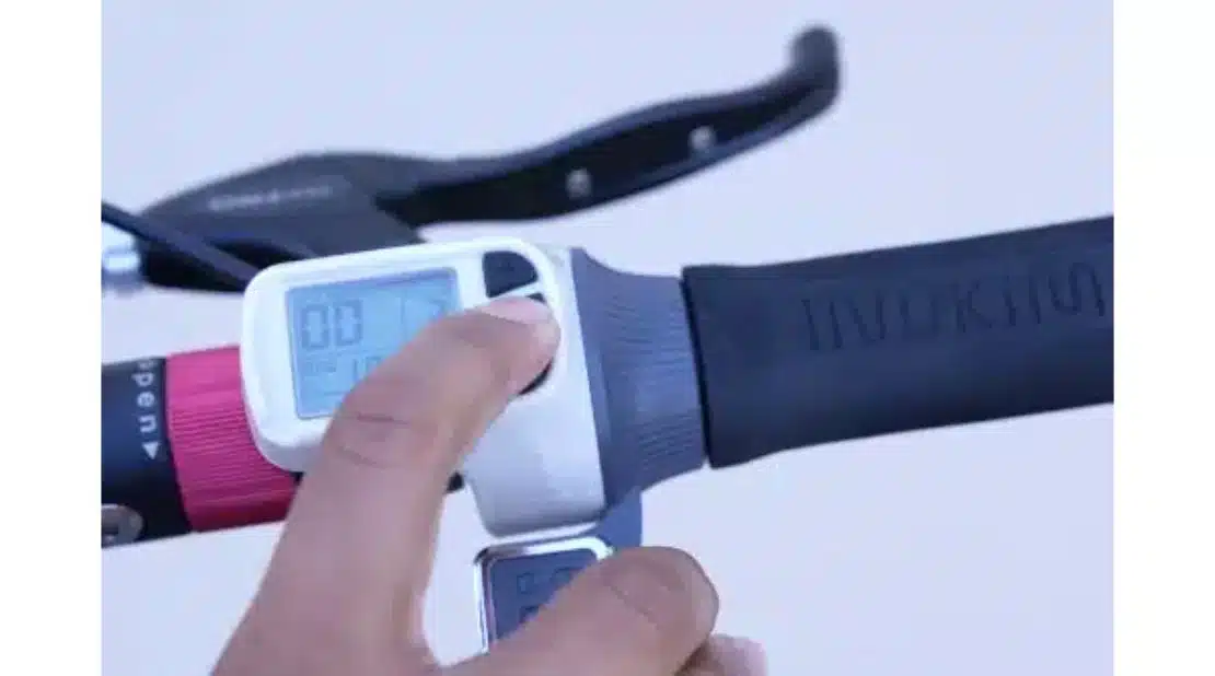 Finger pushing buttons on an electric scooter control panel 