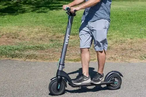 man riding the levy electric scooter on pavement
