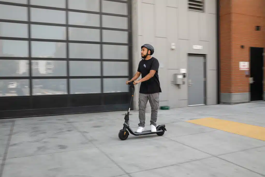 man riding segway ninebot e2 electric scooter on a sidewalk