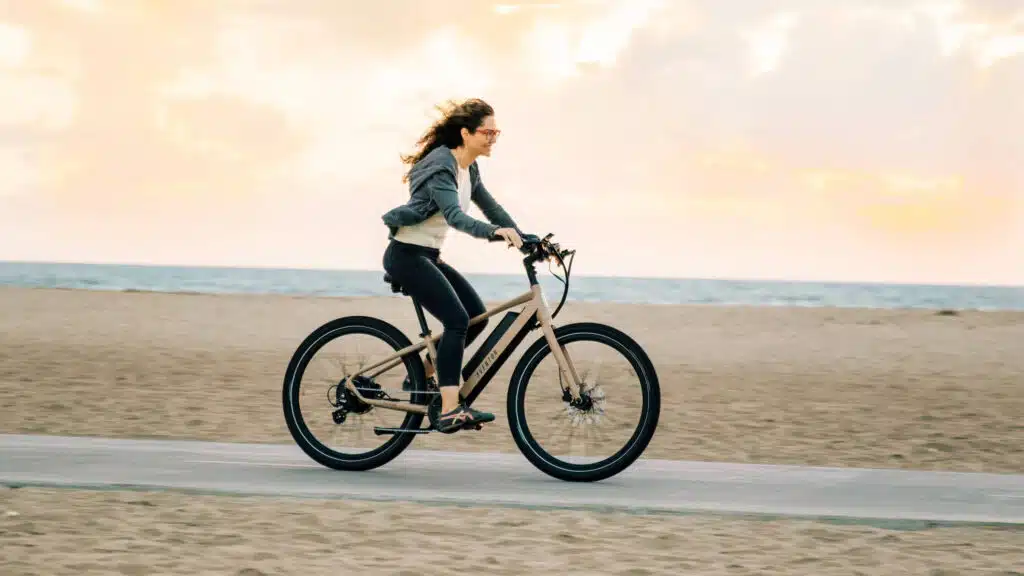 woman riding an electric bike on a beach