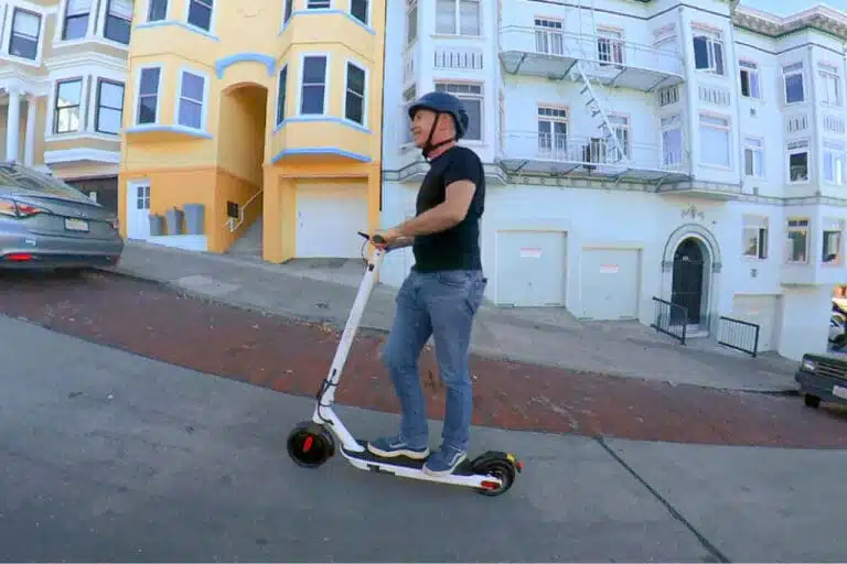 man on a hover-1 journey max electric scooter riding up a hill in San Francisco