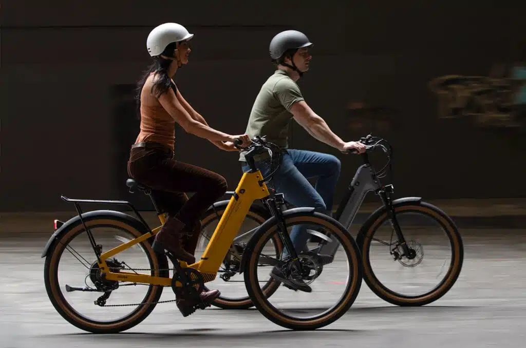 a man and a woman riding Velotric electric bikes