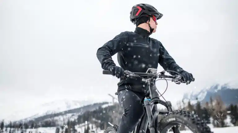 man in snowy mountains on mountain bike wearing winter cycling gloves