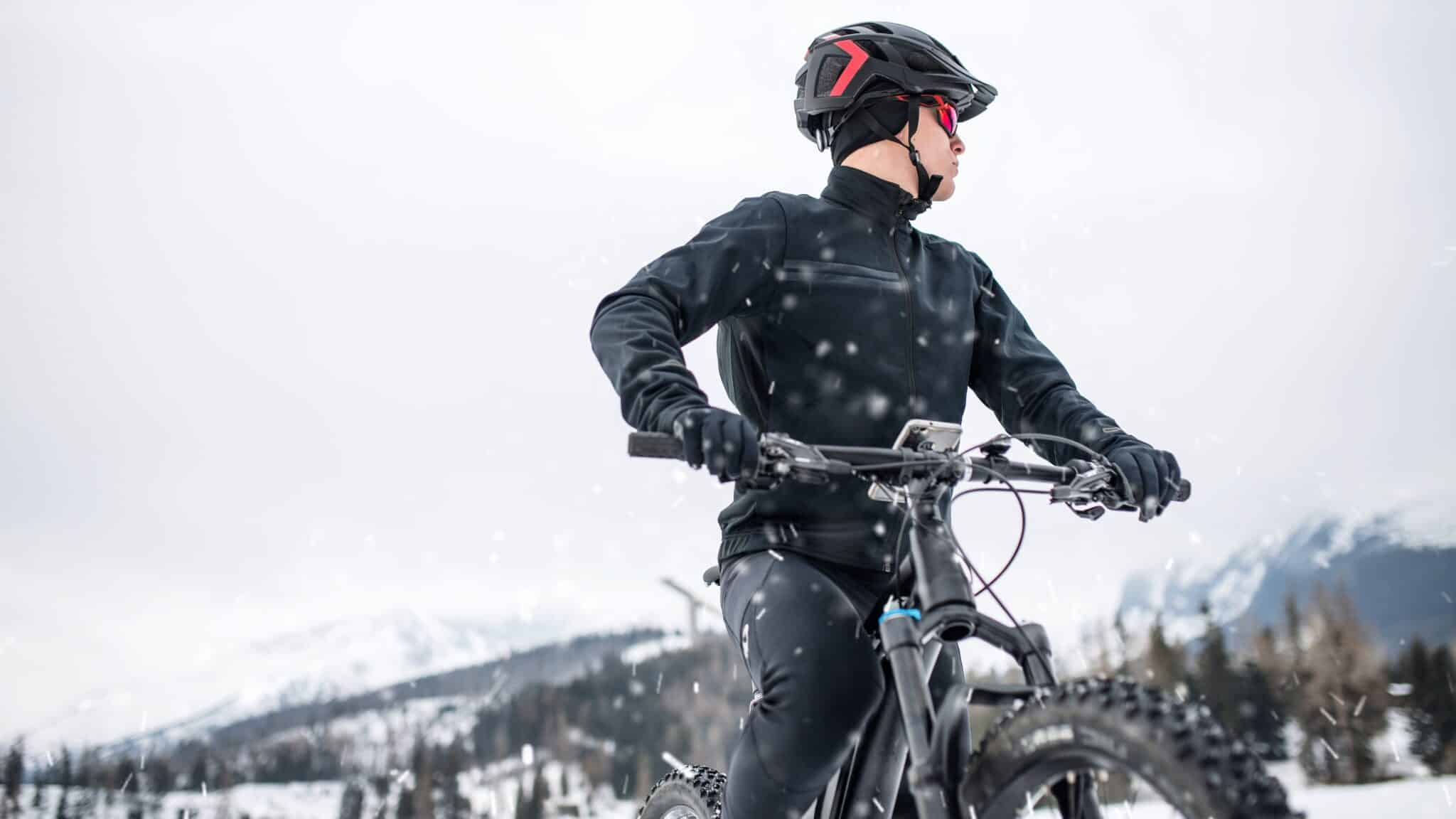 man in snowy mountains on mountain bike wearing winter cycling gloves