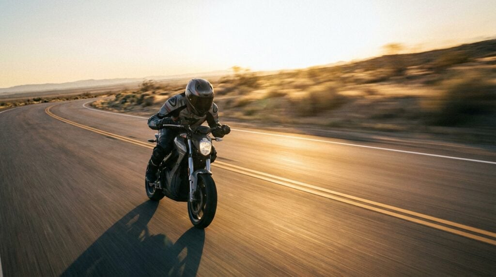 A high-performance electric scooter ridden at speed on an open road