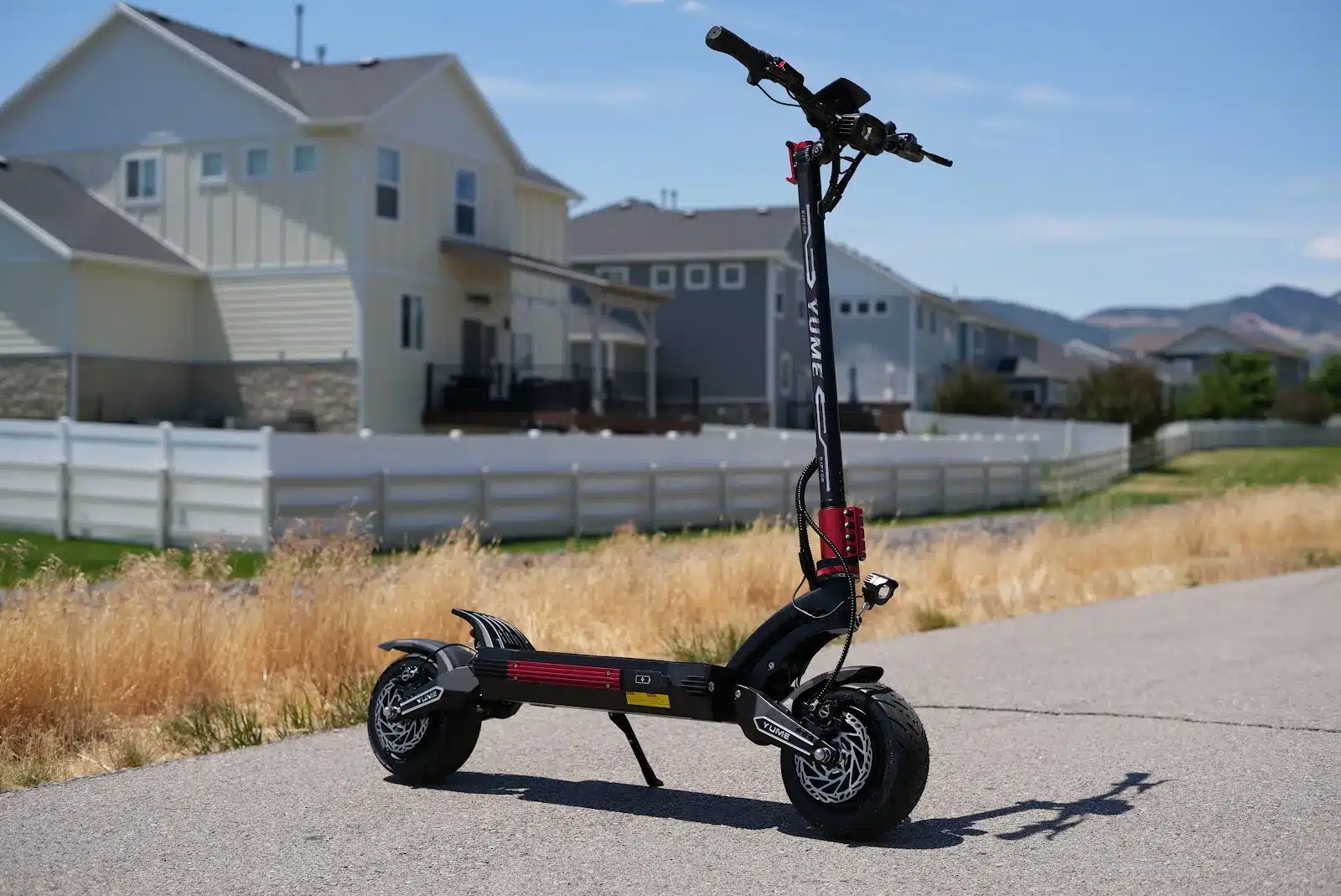 YUME Raptor 2 handling and stance YUME Raptor 2 dual-motor electric scooter front three-quarter view showing its long wheelbase and deep-lean geometry