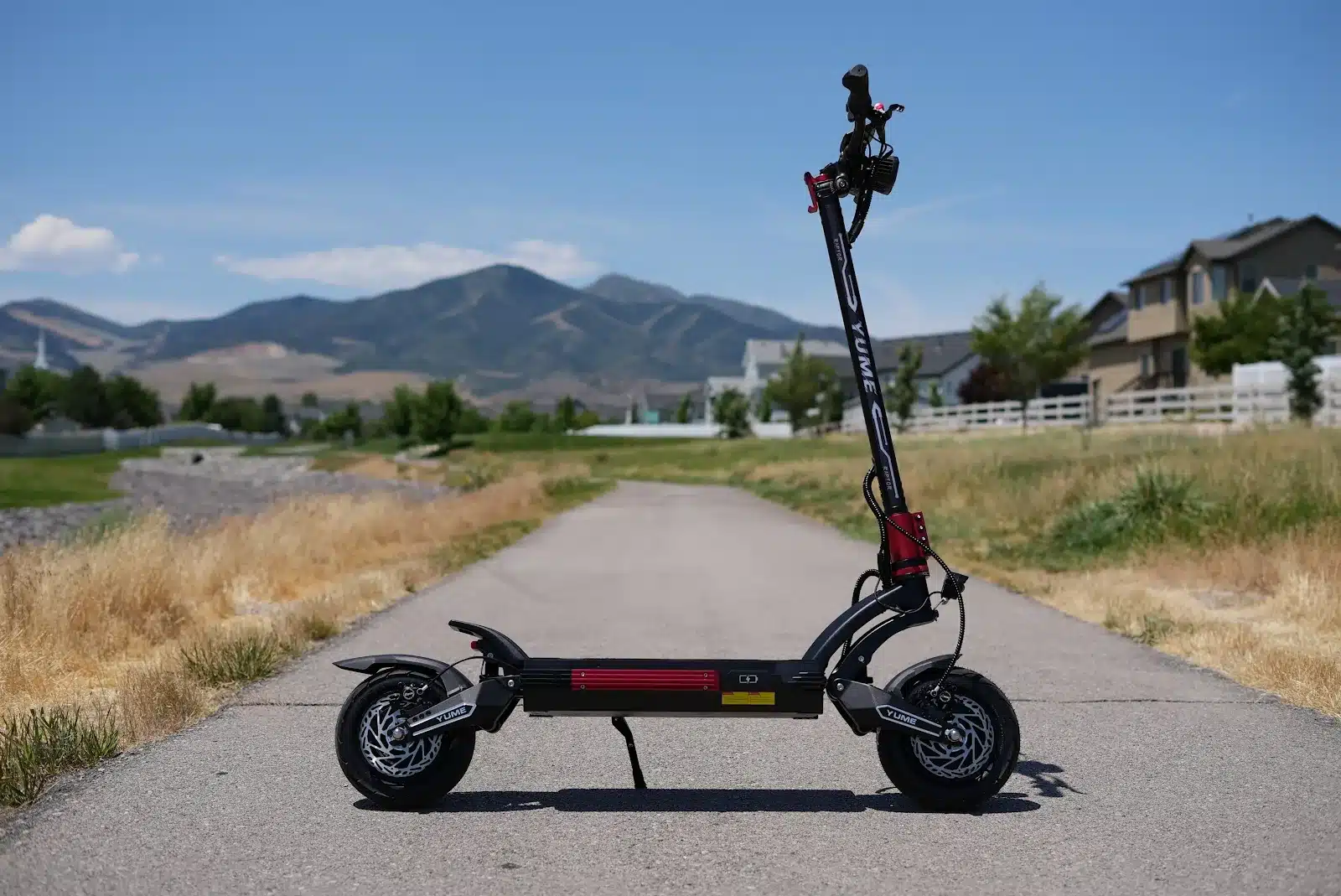 YUME Raptor 2 side profile YUME Raptor 2 electric scooter side profile parked on a paved path with mountains in the background